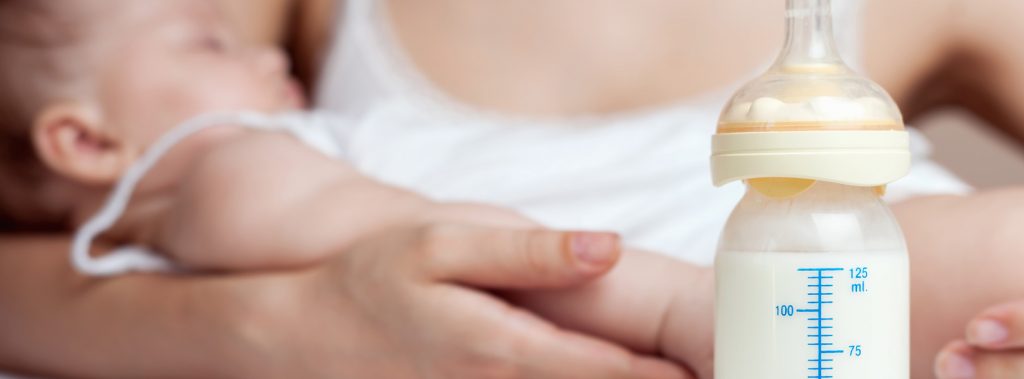 Breastfeeding. Mother, child and breast milk in bottle.