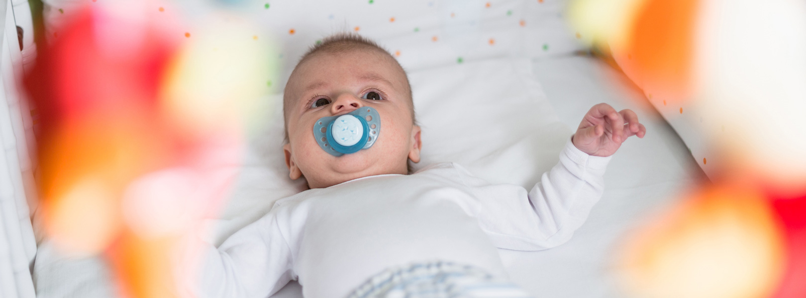 Two months old baby boy lying in the his crib.