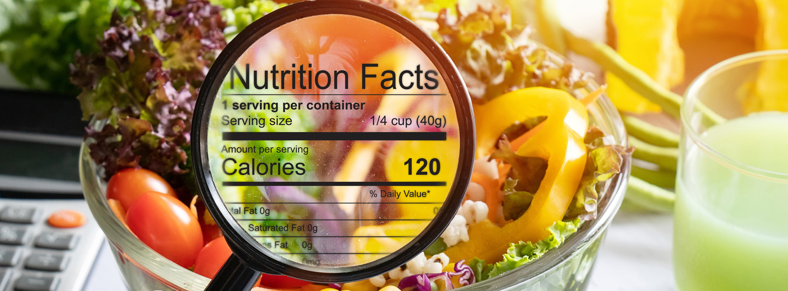 Hand using magnifying glass to zoom in to see the details of the nutrition facts from salad