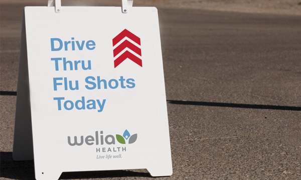 Parking lot sign that says, "Drive Thru Flu Shots Today"