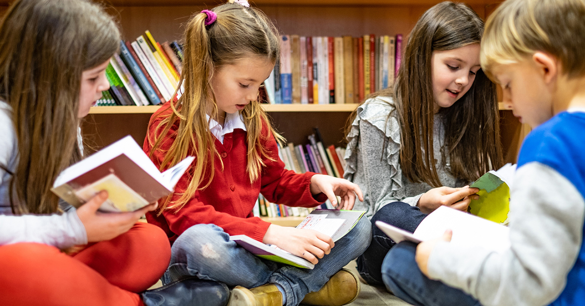 Three children sitting and reading books together