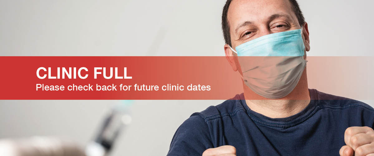 Man in a blue shirt with dark hair wearing a mask getting a COVID shot in the right arm. Clinic Full. Please check back for future clinic dates.