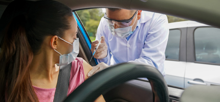 Woman getting vaccination while sitting in her car
