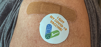 Closeup of arm with an I Got My COVID-19 Vaccine sticker
