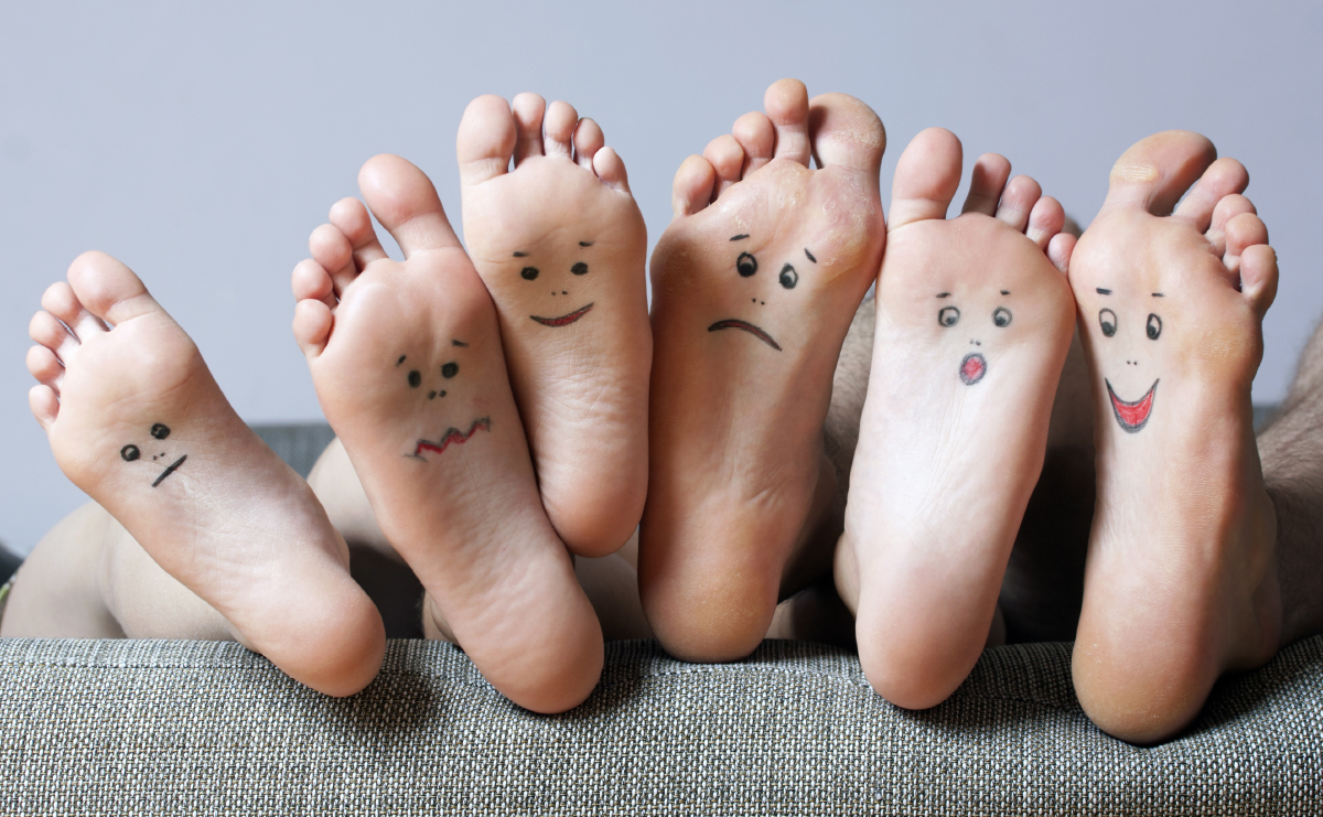 Close up of several feet, all with faces drawn on them