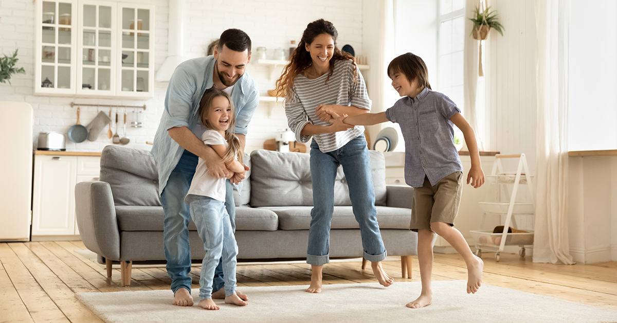 Young family dancing in their living room