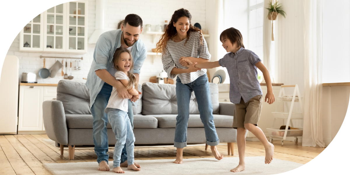 A young family dancing in their living room