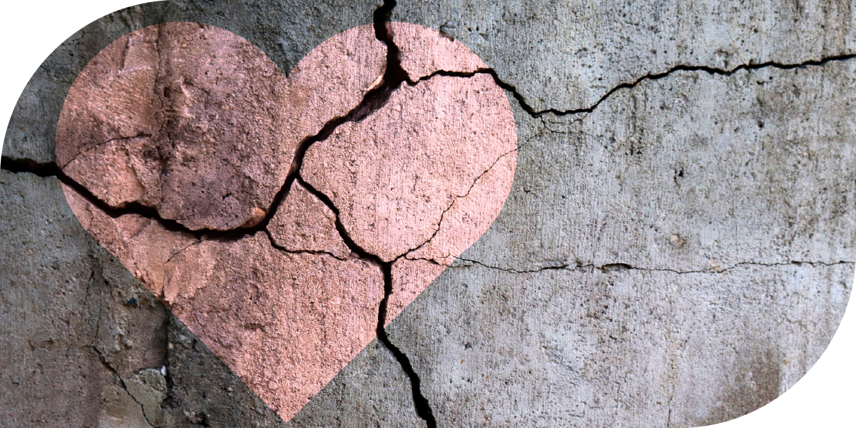 A heart painted on a surface that is cracked and broken