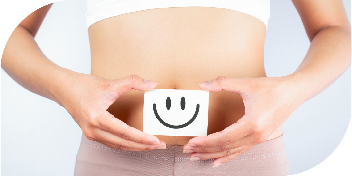 Picture of a woman holder a happy face sign in front of the stomach