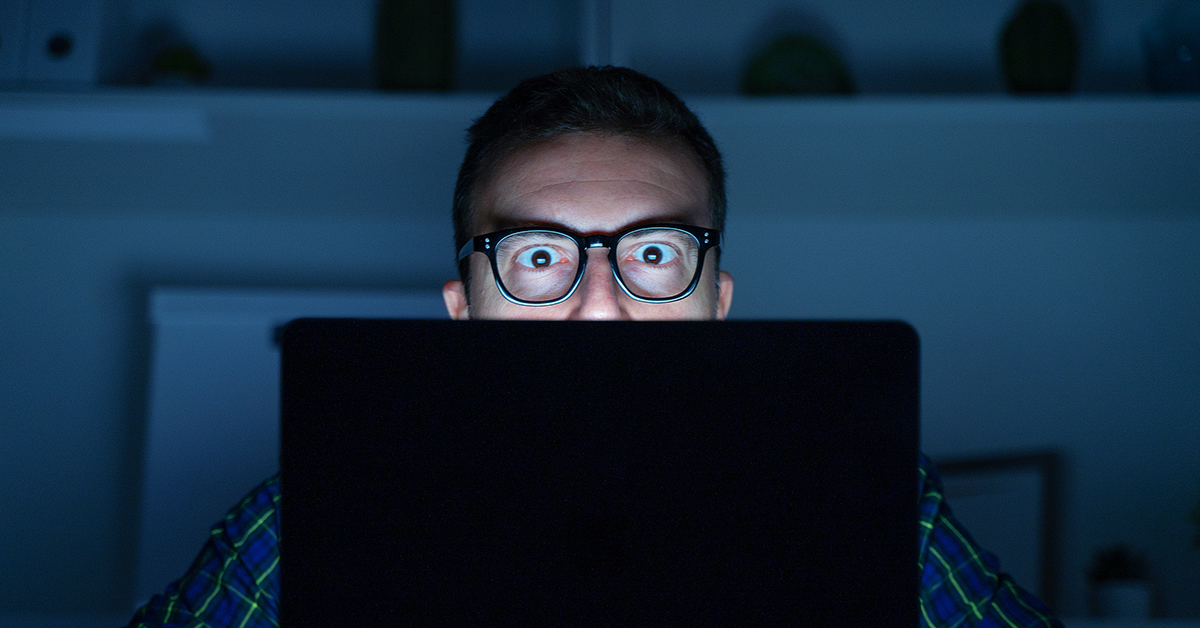 Man staring at his computer screen in the dark