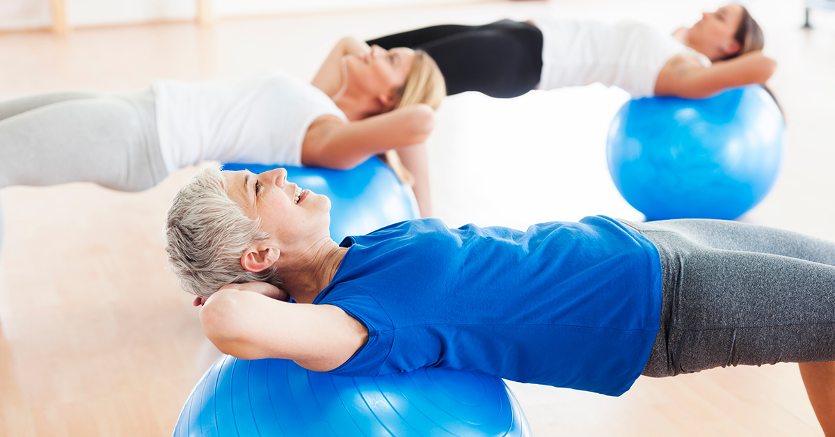 Three older women exercising using stability balls