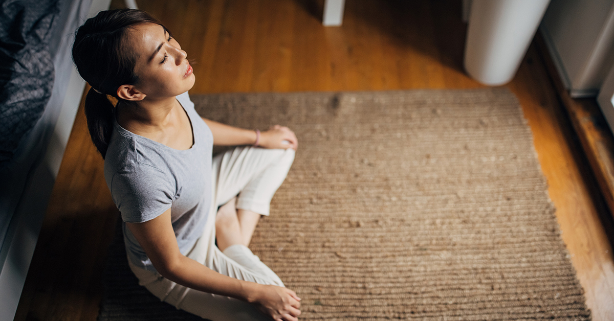 A woman meditating on a rug