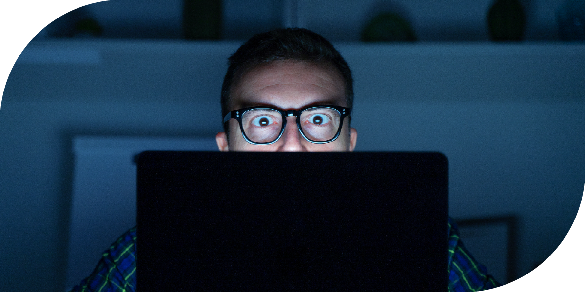 Man staring ast his computer screen in the dark