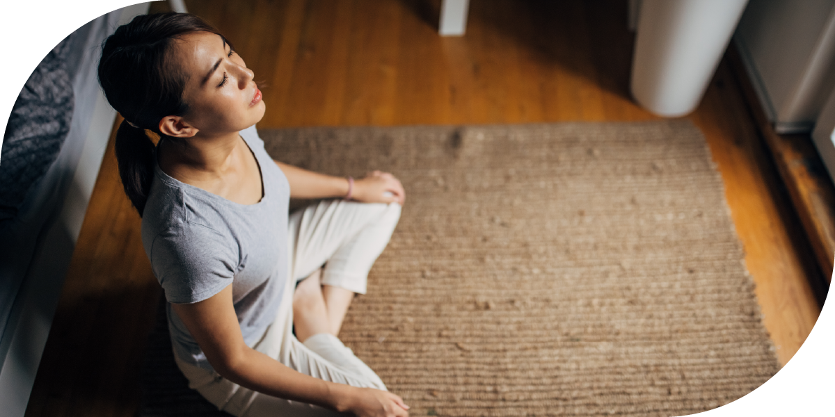 A woman meditating on a rug