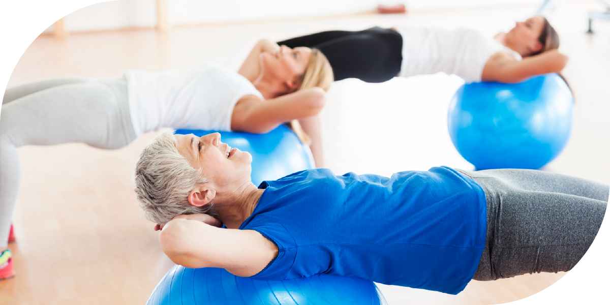 Three older women exercising using stability balls
