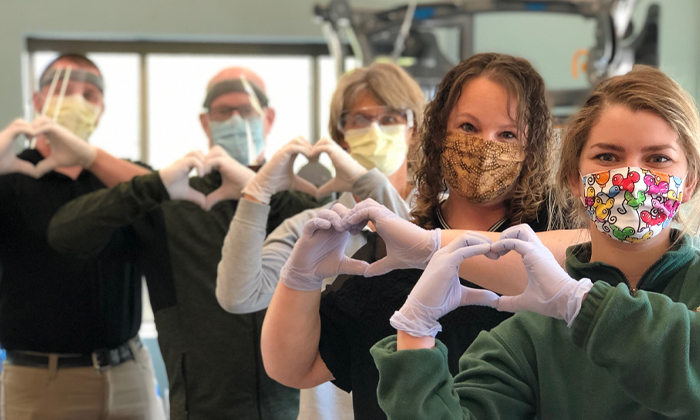 Rehabilitation staff holding hands in the shape of hearts