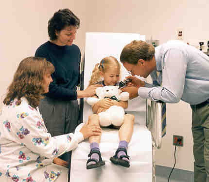 Dr. Peter Donner checking a little girl's teddy bear