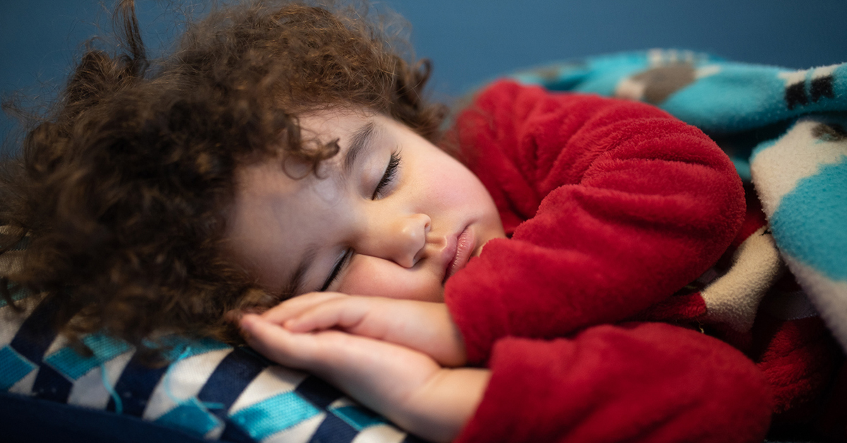 Young child sound asleep in bed