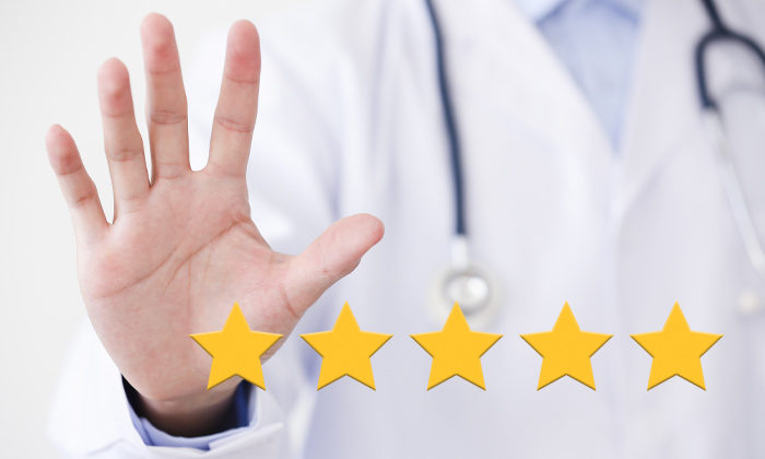 Doctor's hand showing five fingers, along with 5 gold stars in forefront