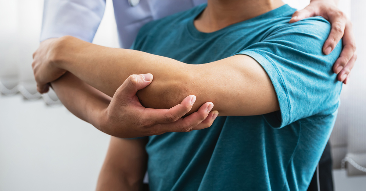 Physical therapist working with a patient on his shoulder