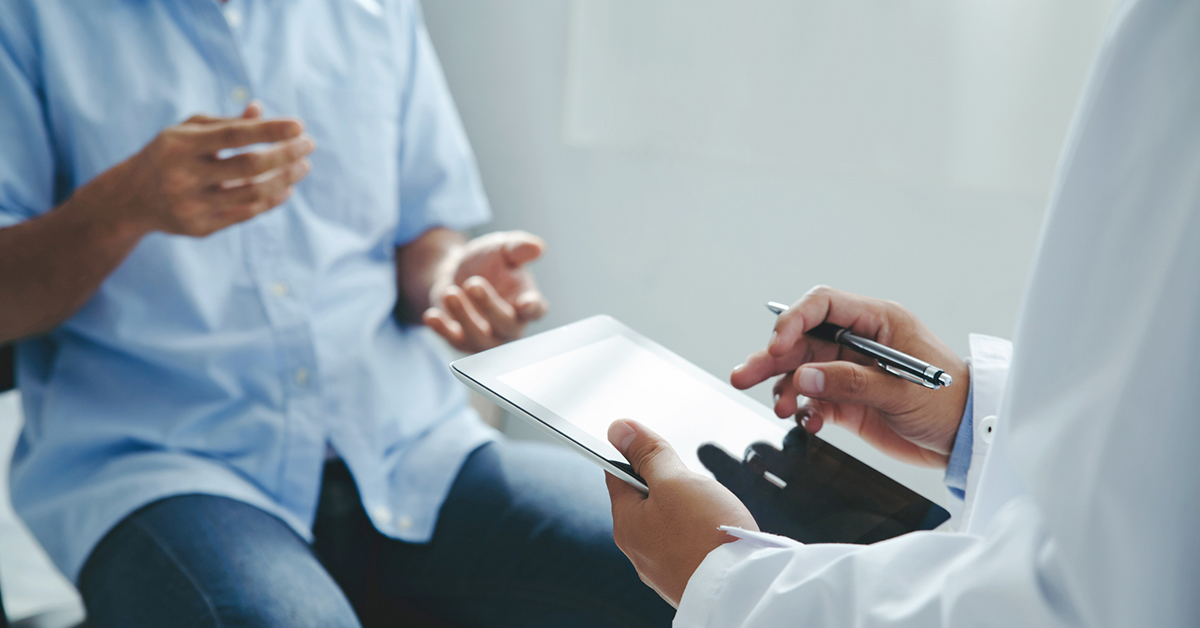 Doctor in an exam room talking to a male patient