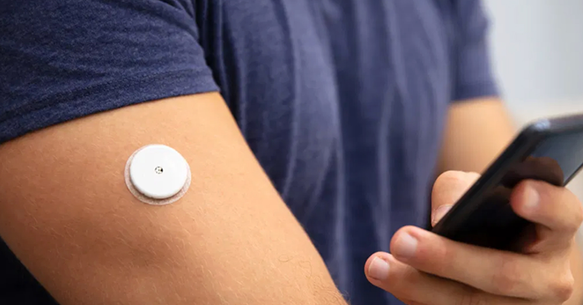 Man wearing a continuous glucose monitor on his arm