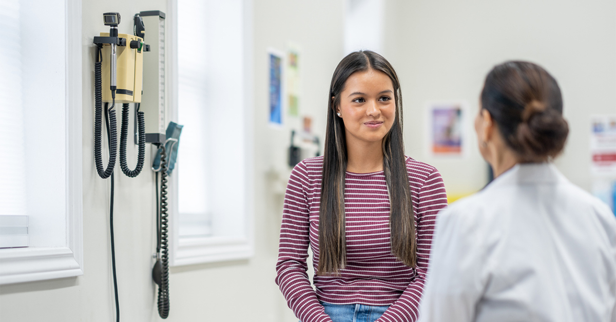 A female student-athlete in an exam room for a sports physical
