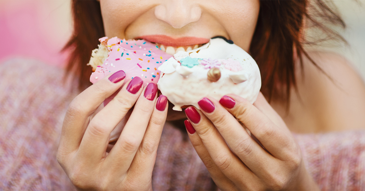 Women taking a bite of a doughnut