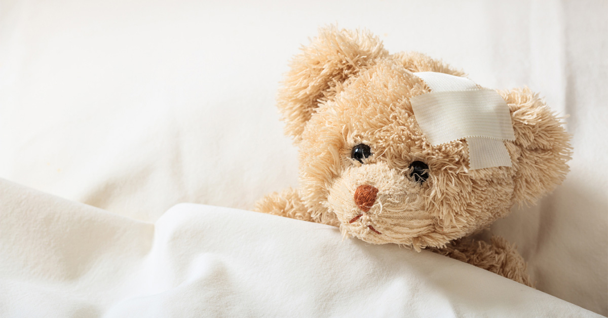 A teddy bear with a bandage on its head