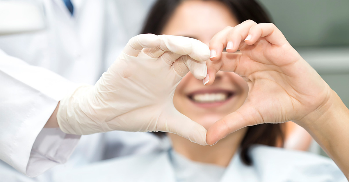 Patient and doctor making 'heart hands' together