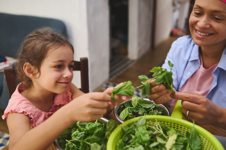 Mother and daughter preparing a salad.