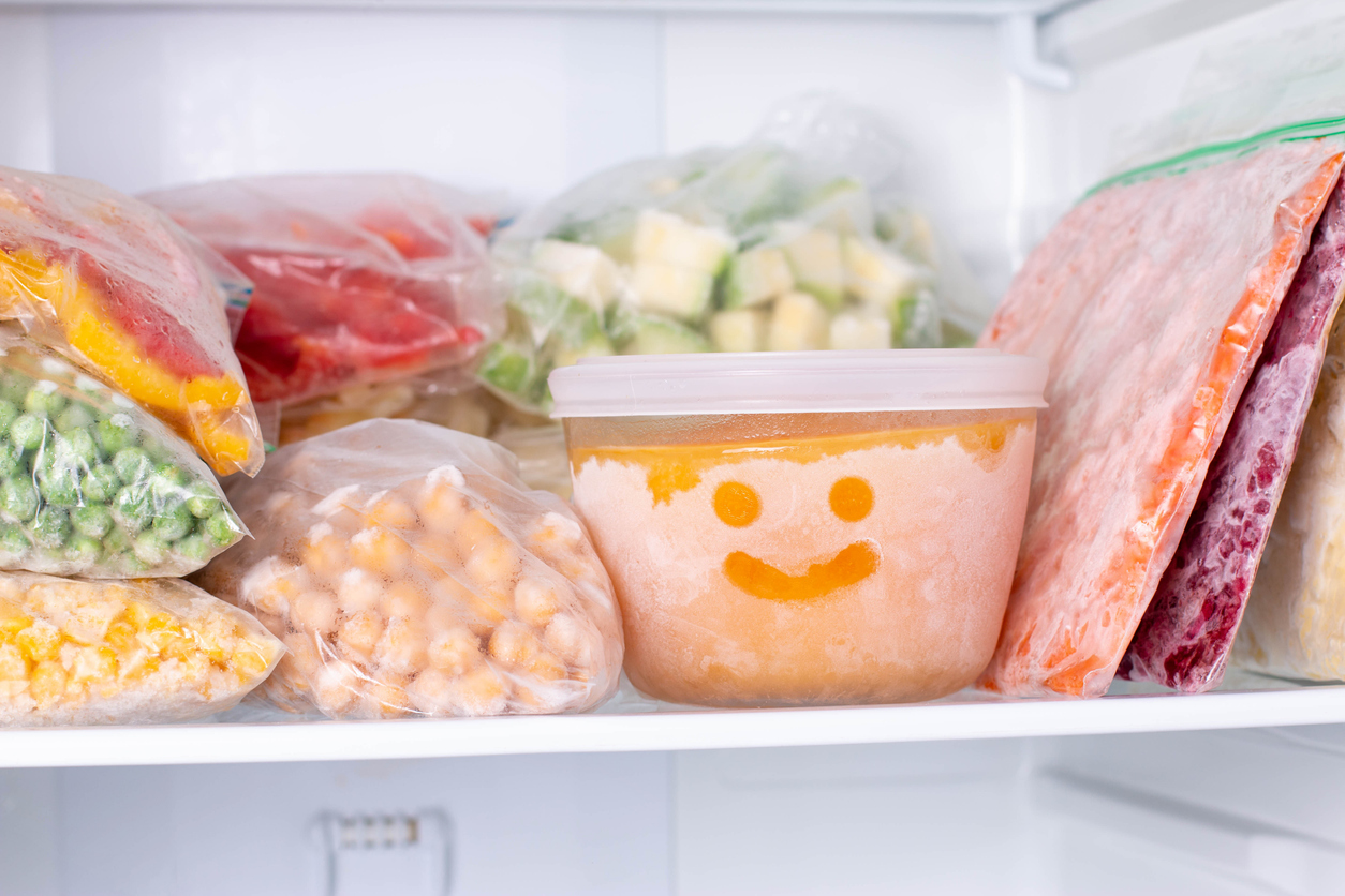 A freezer filled with storage bags and containers of veggies and other meal prep items