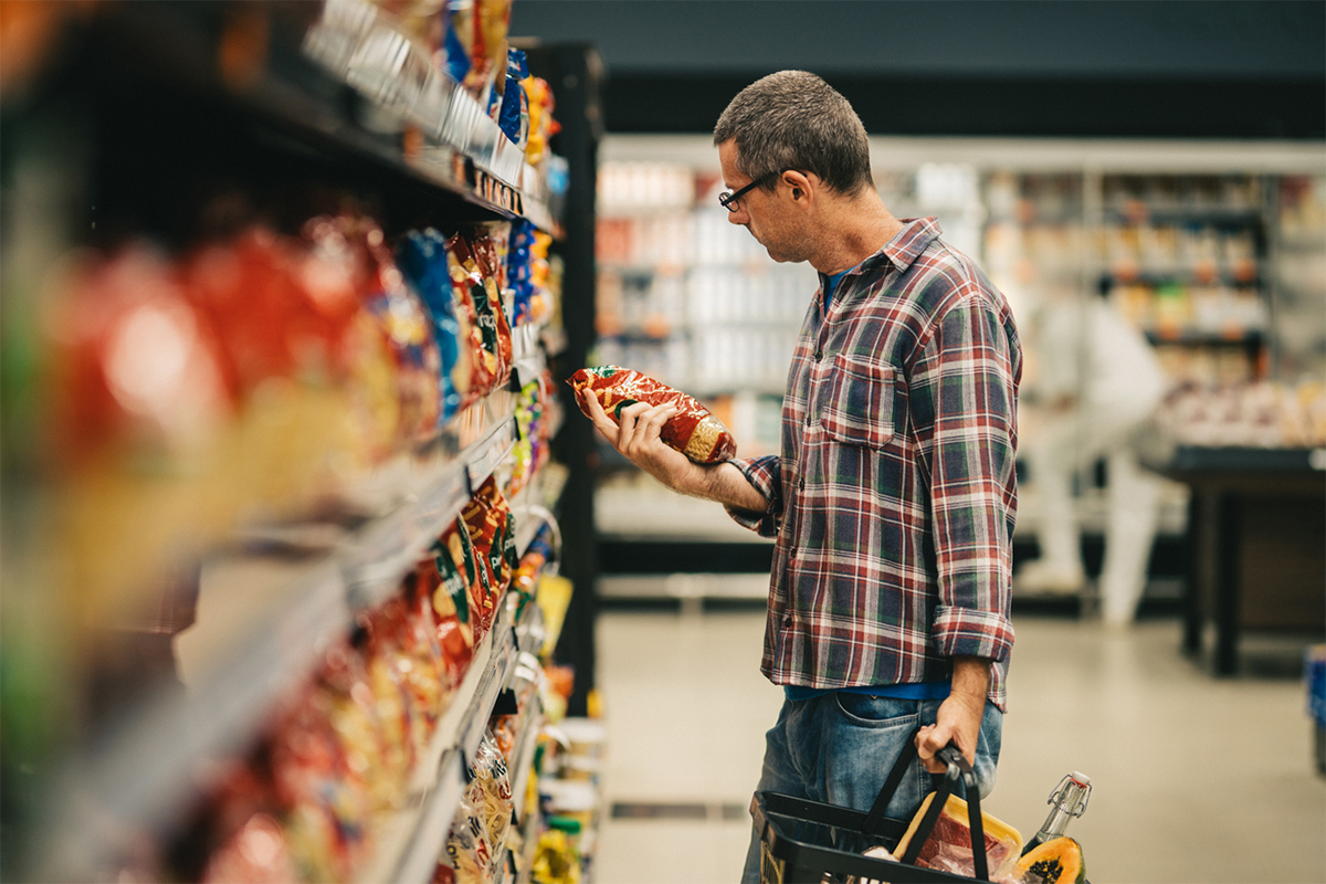 Man in a grocery store reading food labels