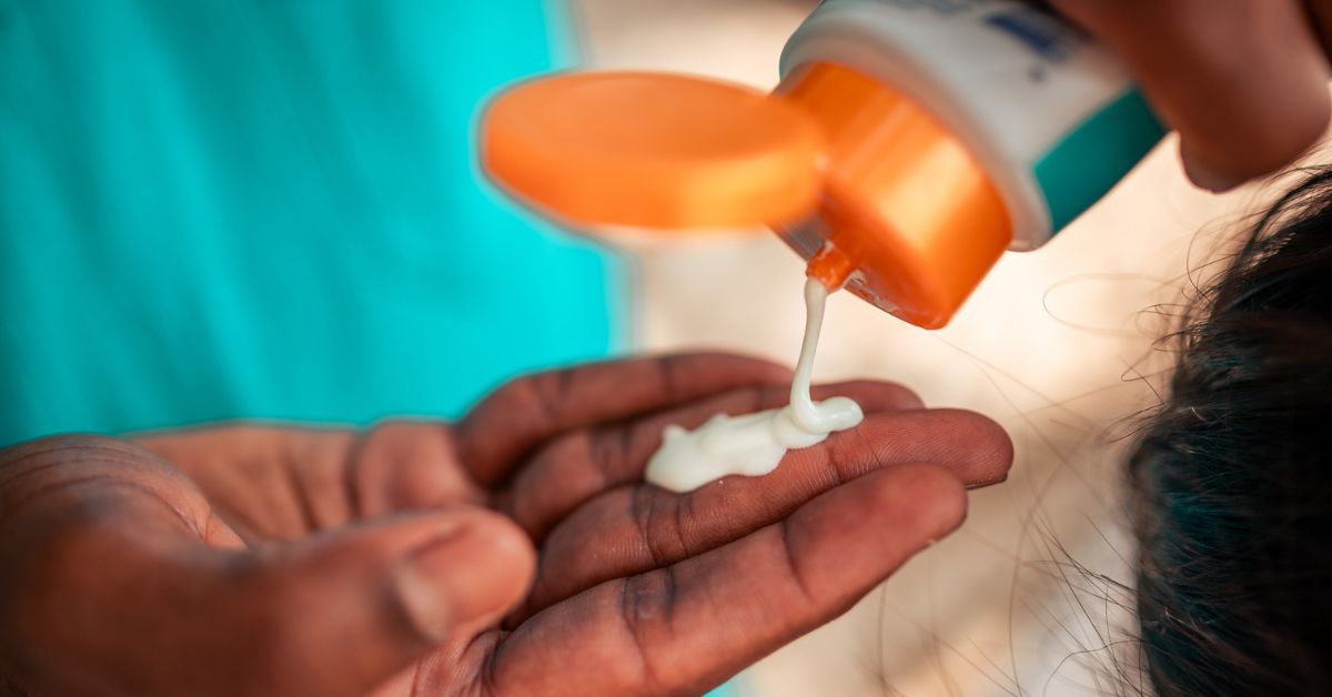 Closeup of individual with a generous amount of sunscreen on their hand